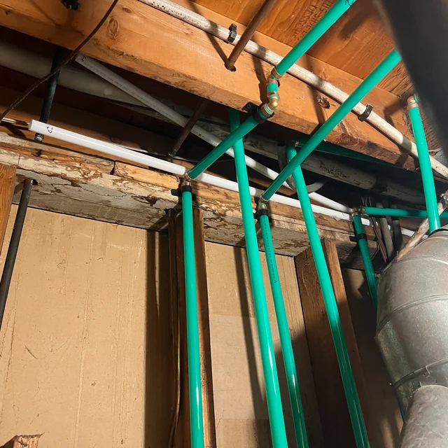 Exposed green heating pipes in the Burnaby hydronic pipe replacement project